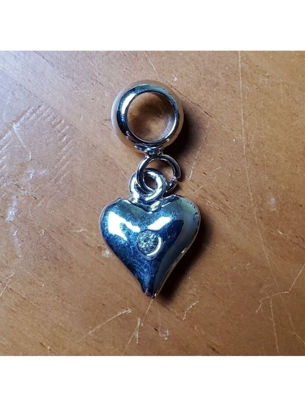 NWOT charm, silver colored heart with clear stone in center